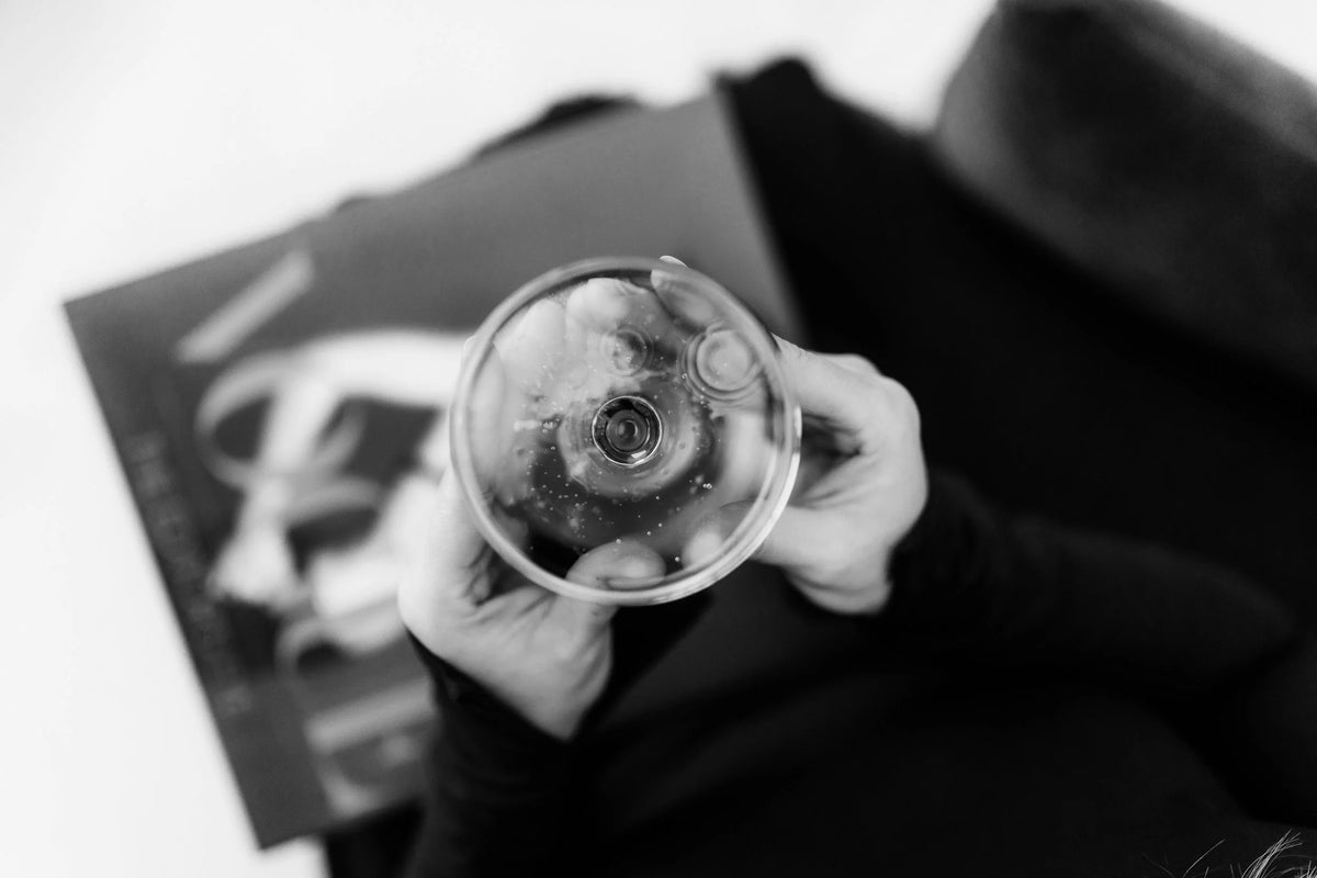 Sparkling wine in a coupe glass held above a magazine at Eve Salon, Saint Louis MO
