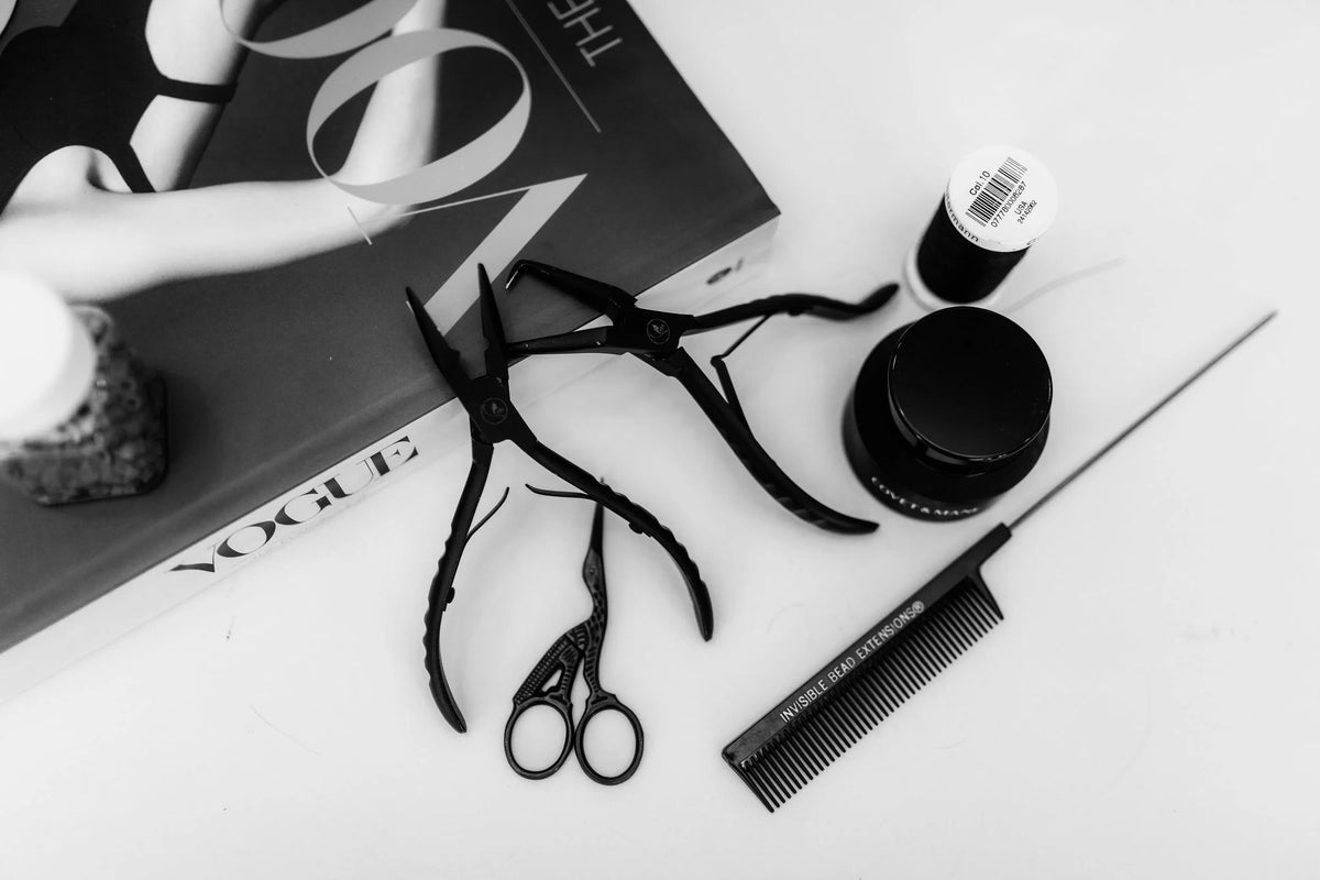 Hair extension pliers, shears and a styling comb laid out at Eve Salon, Saint Louis MO